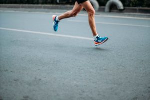 Läufer lauft mit Laufschuhen auf der Straße